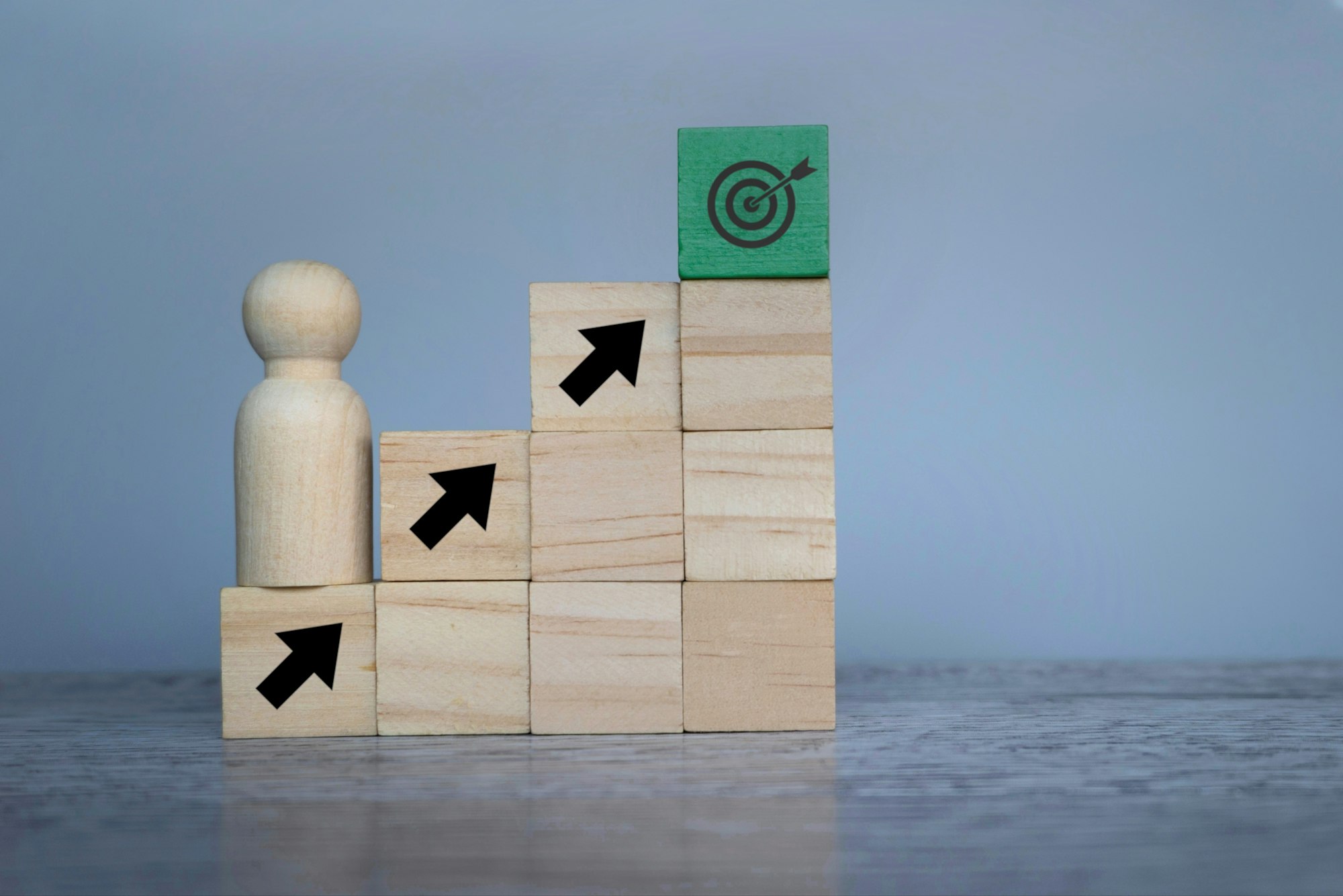 Wooden doll with upward arrows and target board.